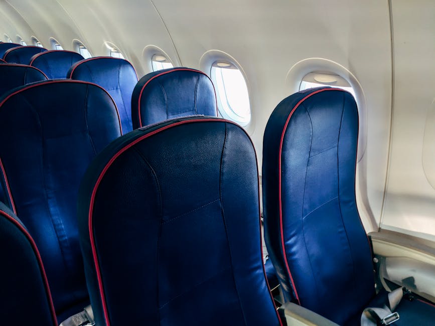 Empty airplane cabin with window seats lit by daylight