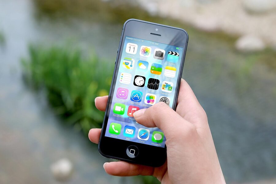 A hand holding a smartphone showing a messaging interface