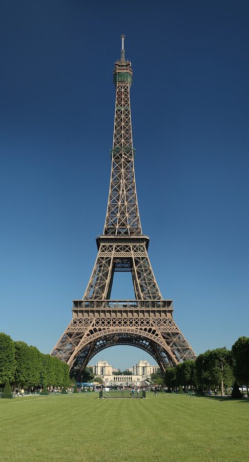 Eiffel Tower lit up at dusk with the Seine in the foreground, Paris