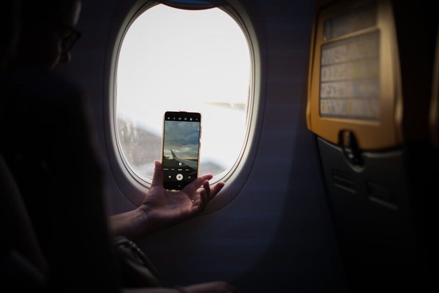 Passenger using a phone near an airplane window