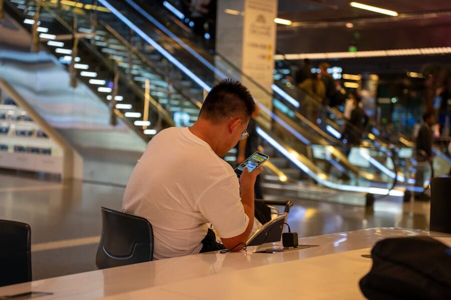 Traveler using a smartphone inside a modern airport terminal