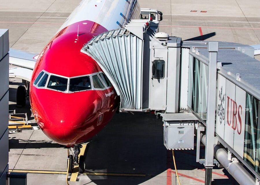 Airliner parked at airport terminal gate with jet bridge attached