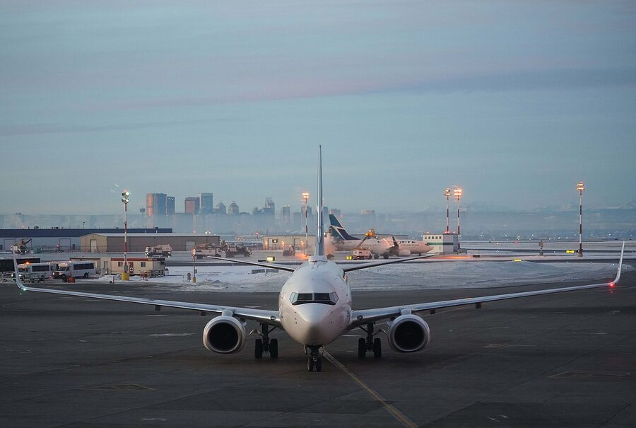 WestJet Boeing 737 parked at gate with Calgary skyline in background