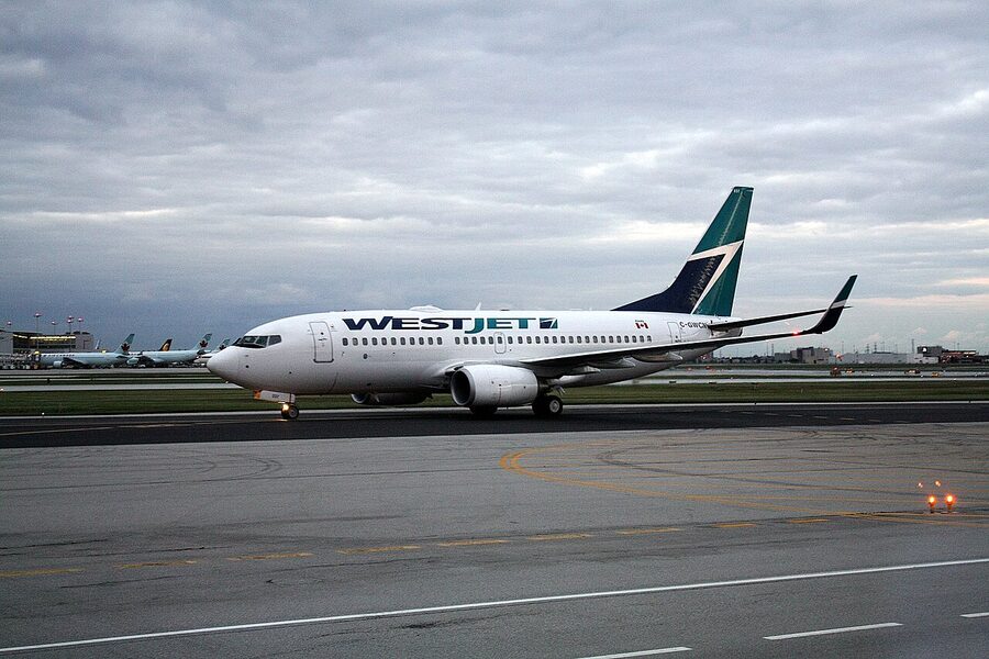 WestJet Boeing 737 taxiing past terminal