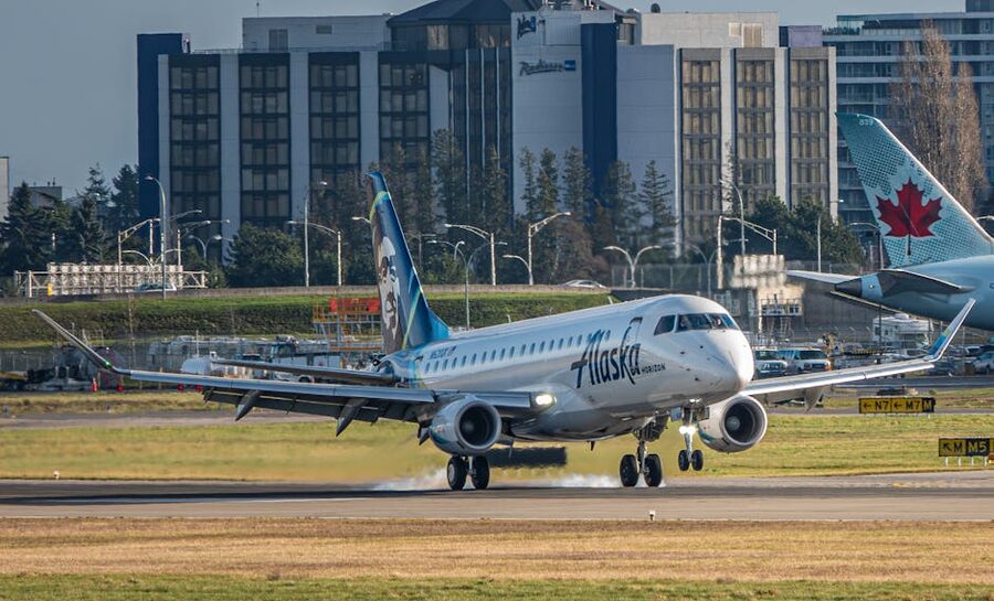 Alaska Horizon regional airplane landing on a runway with buildings in background