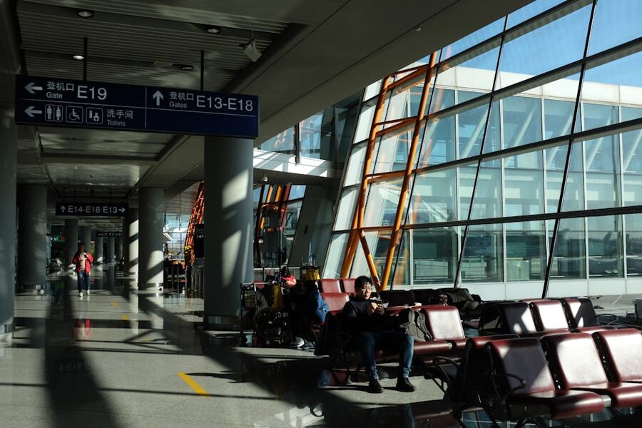 Modern airport terminal with seated passengers and directional signs