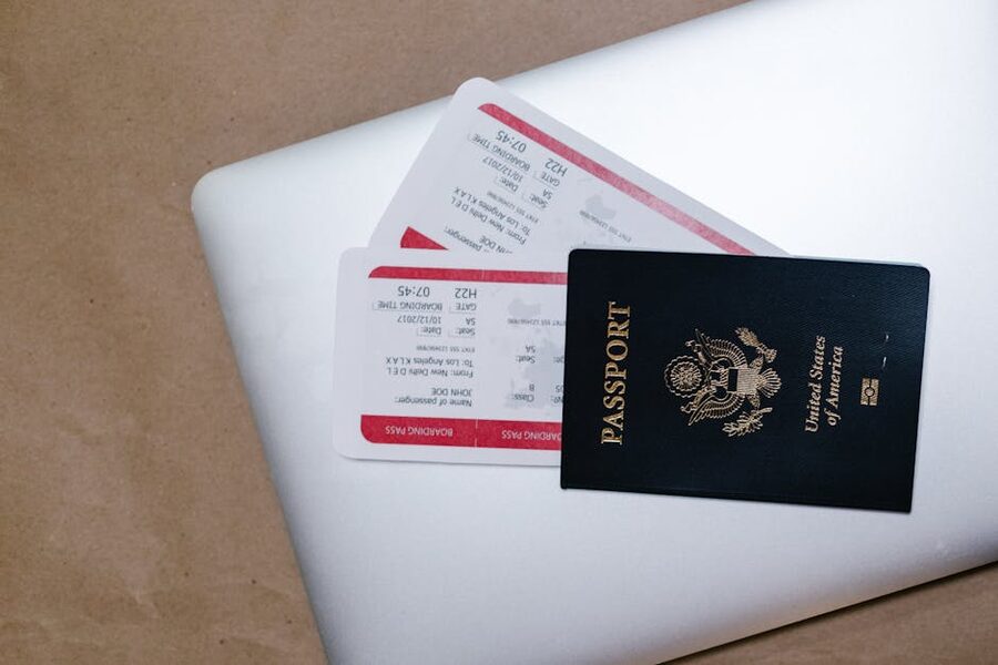 Passport and boarding passes resting on an open laptop